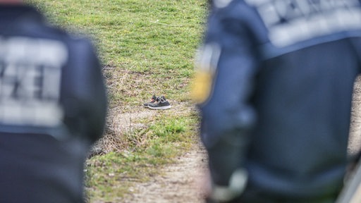 Polizisten stehen an einer Stelle, wo ein paar Schuhe gefunden wurden (Archivbild)