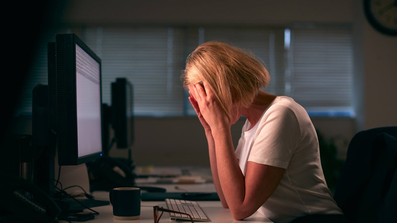 Eine Frau resigniert vor Stress am Arbeitsplatz (Symbolbild)