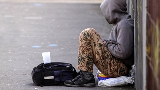 Junger Mann bettelt auf der Straße
