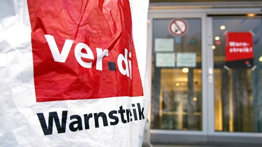 Warnstreik-Transparent vor einem Telekom-Gebäude.