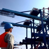 Hafenarbeiter blickt auf eine Containerbrücke