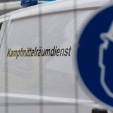 Fahrzeug eines Kampfmittelräumdienstes hinter einem Zaum mit Schild (Symbolbild)