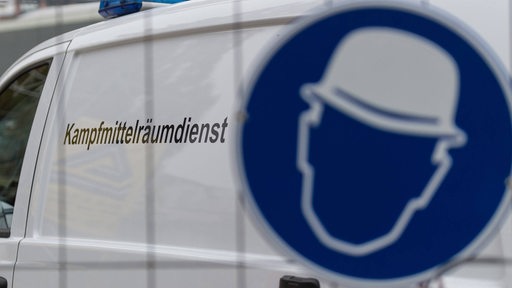 Fahrzeug eines Kampfmittelräumdienstes hinter einem Zaum mit Schild (Symbolbild)