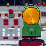 Warnbarken und -leuchten an einer Baustelle.