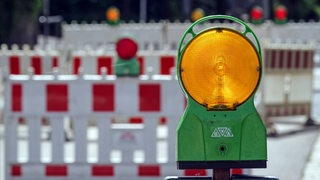 Warnbarken und -leuchten an einer Baustelle.