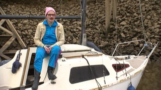 Eine Frau sitzt auf einem kleinen Boot