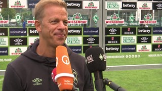 Werder-Trainer Markus Anfang spricht nach dem Testspiel gegen St. Petersburg in mehrere Mikrofone.