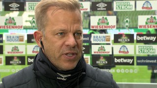 Werder-Trainer Markus Anfang nach dem Remis gegen St. Pauli vor einer Werbewand im Interview.