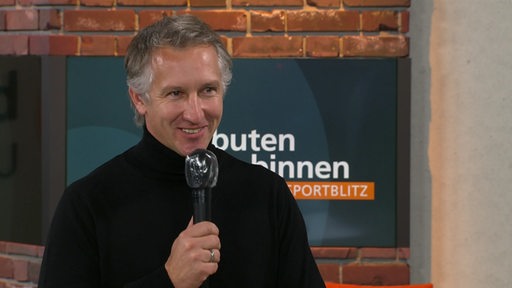 Werder-Sportchef Frank Baumann lächelt beim Interview im buten-un-binnen-Studio-