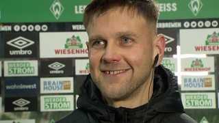 Werder-Stürmer Niclas Füllkrug grinst bei einem Interview nach dem Spiel.