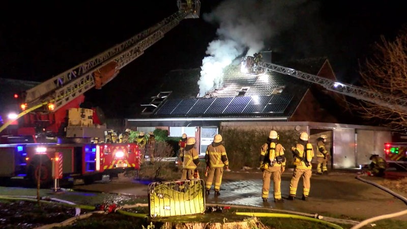 Im Dachgeschoss eines Einfamilienhauses lodert ein Feuer. 