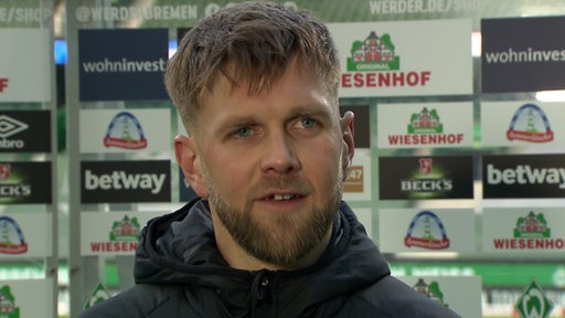 Werder-Stürmer Niclas Füllkrug nach dem Spiel beim TV-Interview vor einer Werbewand.