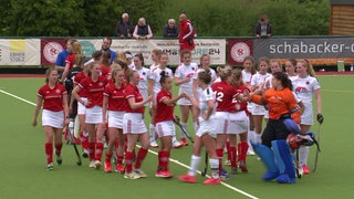 Die Hockey-Spielerinnen des Bremer HC klatschen nach dem Sieg die Gegnerinnen aus Krefeld ab.