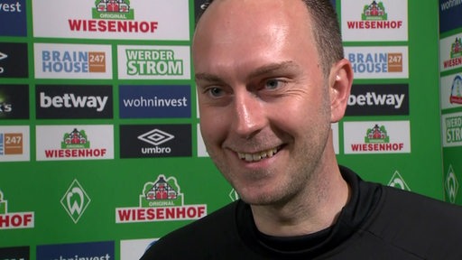 Werder-Trainer Ole Werner strahlt beim Interview nach dem Aufstieg.
