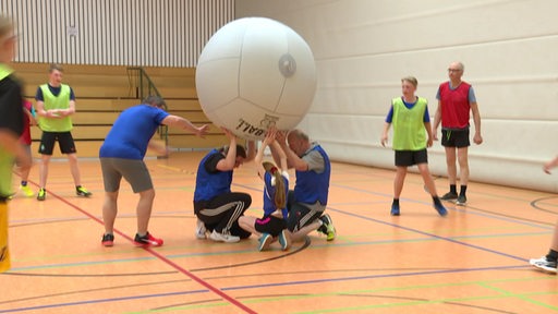 Menschen spielen mit einem großen Ball