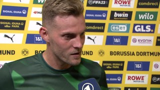 Werder-Stürmer Marvin Ducksch vor einer Werbewand nach dem Sieg in Dortmund beim Interview.