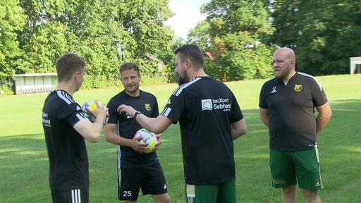 Fußballer Philipp Bargfrede spricht im Training mit seinen Teamkollegen vom Heeslinger SC.