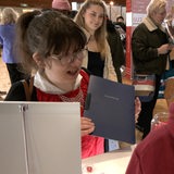 Eine junge Frau hält eine Bewerbungsmappe in der Hand.