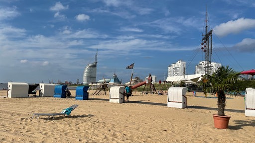 Uitzicht op het zandstrand met strandstoelen.