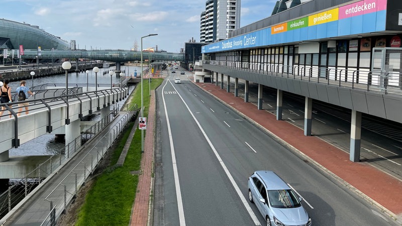 Blick auf eine breite Straße. Rechts ist ein Gebäude mit der Aufschrift "Columbus Center" zu sehen, links ist ein Hafenbecken.