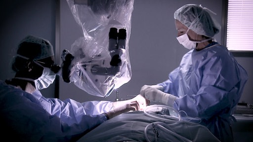 Zwei Ärzte operieren einen Patieten im Operationssaal. 