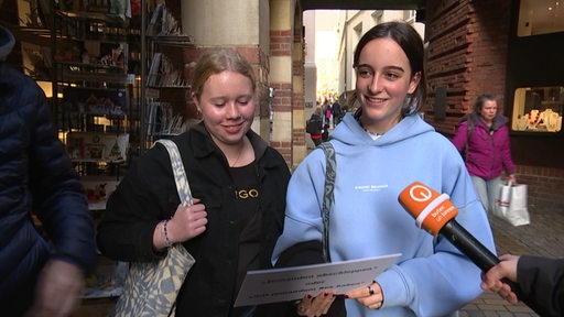 Zwei Mädels werden in der Bremer Innenstadt interviewt.