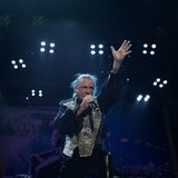 Der Sänger von Iron Maiden hebt auf der Bühne die Hände in den Höhe. 