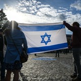 Demonstranten halten eine israelische Fahne hoch. 
