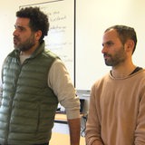 Ein Israeli und ein Palästinenser stehn in einem Klassenzimmer.
