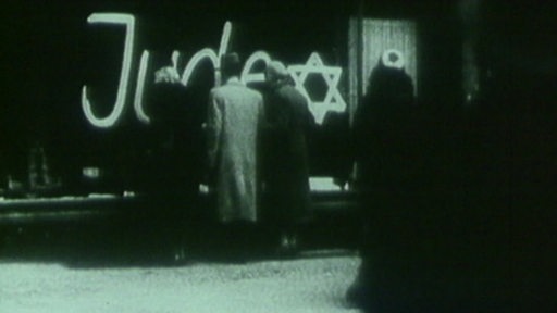 Ein altes Foto von einem Schaufenster in dem die Aufschrift "Jude" mit dem Judenstern steht.