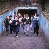 Gruppe Jugendlicher, einige mit Schädel in der Hand, sprinten aus Fußgängertunnel Richtung Kamera