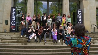 Eine Gruppe junger Menschen stellt sich vor der Bremer Kunsthalle für ein Foto auf.