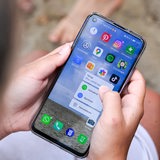 Eine Jugendliche hält ein Smartphone in den Händen, auf dem u.a. die TikTok-App zu sehen ist.