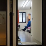 Ein Insasse einer JVA sitzt in seiner Zelle auf dem Bett und schaut aus dem Fenster (Symbolbild)