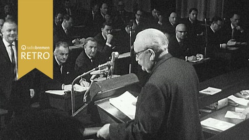 Wilhelm Kaisen spricht am Rednerpult vor den Abgeordneten