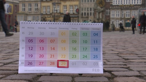 In einem Kalender ist der 29. Febrar markiert. Der Kalender steht auf dem Kopfsteinplfaster in der Bremer Innenstadt.