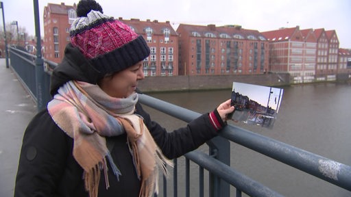 Die Sängerin Kamila Dunajska zeigt ein Foto auf einer Weserbrücke.