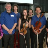 Musiker des Kammerensembles Konsonanz schauen in  die Kamera, ihre Instrumente in der Hand.