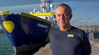 Der gebürtige Bremer Kapitän der Humanity1 Joachim Ebeling vor dem Schiff.