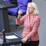 Eine Frau steht an einem Pult und spricht.