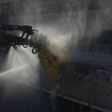Ein Bagger mit einer Abrissschere reißt Beton ab