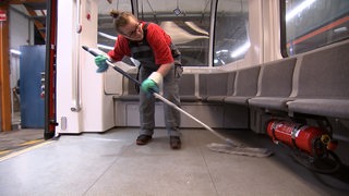 Putzfrau Katja Nietfeld putzt mit einem Wischmob in einer Bahn der BSAG