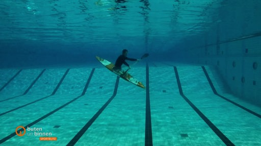 Die Unterwasseraufnahme eines Kayak Freestyle Athleten und seines Boot aus einem Schwimmbad.