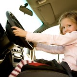 Ein Mädchen sitzt hinter dem Steuer eines Autos