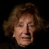 Ältere Dame mit rötlichem Haar vor schwarzem Hintergrund frontal