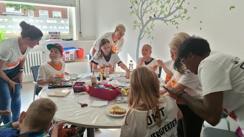 Kinder des Kinderhospiz-Vereins Hombre in Bremerhaven sitzen gemeinsam an einem Tisch.