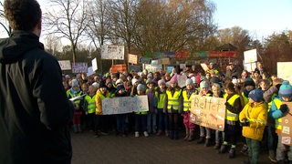 Mehrere Kinder demonstrieren mit selbst gebastelten Plakaten für den Erhalt der Bremer Jugendfarm.