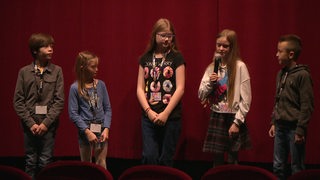 Kinder und Jugendliche der Jury des Kijuko Filmfestes bei einer Rede im Kinosaal