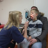 Ein kleiner Junge wird in einer Kinderarzt-Praxis von einer Ärztin untersucht. 