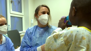 Eine Kinderkrankenschwester kümmert sich um ein Kind.
